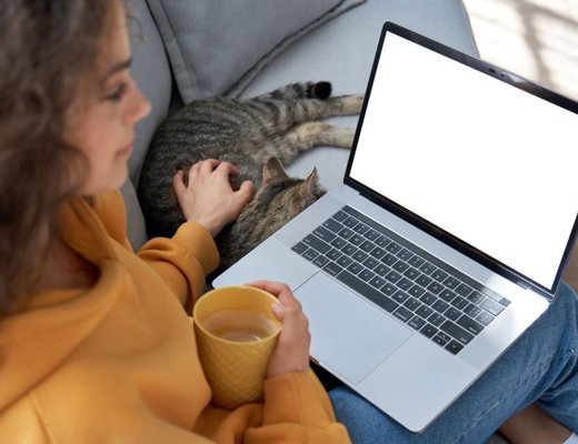 Kvinde, der sidder i sin sofa, mens hun ser undervisningen fra en online uddannelse